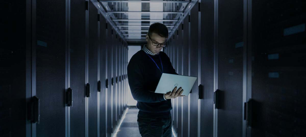 A person checking systems in a data center managing clients services securely and safely.